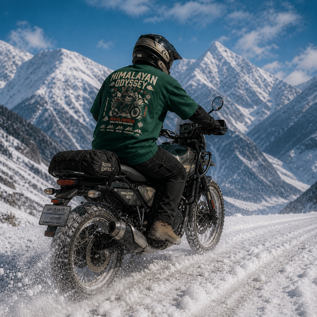 Rider on Royal Enfield Himalayan 450 powering through snow in a bottle green Himalayan Odyssey oversized graphic t-shirt — 260 GSM premium biker tee by ThreadEvoke, India