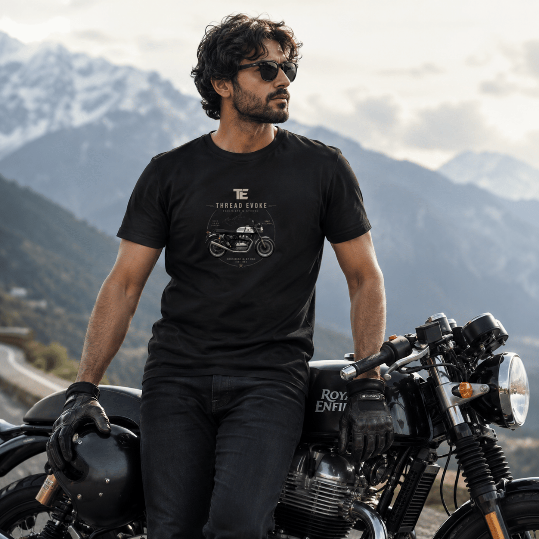 Continental GT 650 rider t-shirt by Thread Evoke worn by a biker leaning on Royal Enfield motorcycle with snow-capped mountains in the background